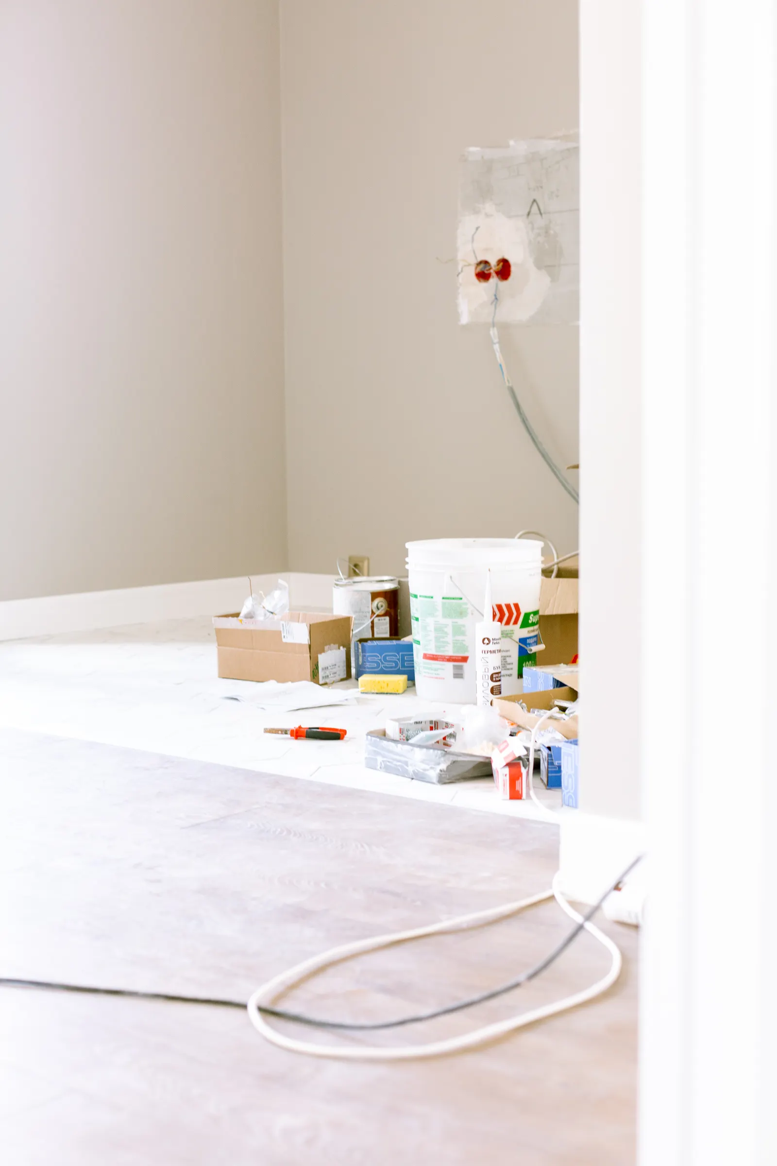 Coin de pièce en rénovation avec pots de peinture et matériel préparé